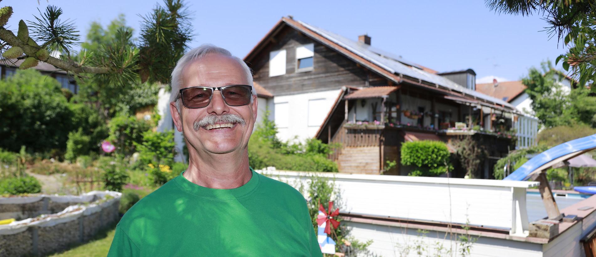 Herr Lacher vor seinem Haus mit PV Anlage & Stromspeicher