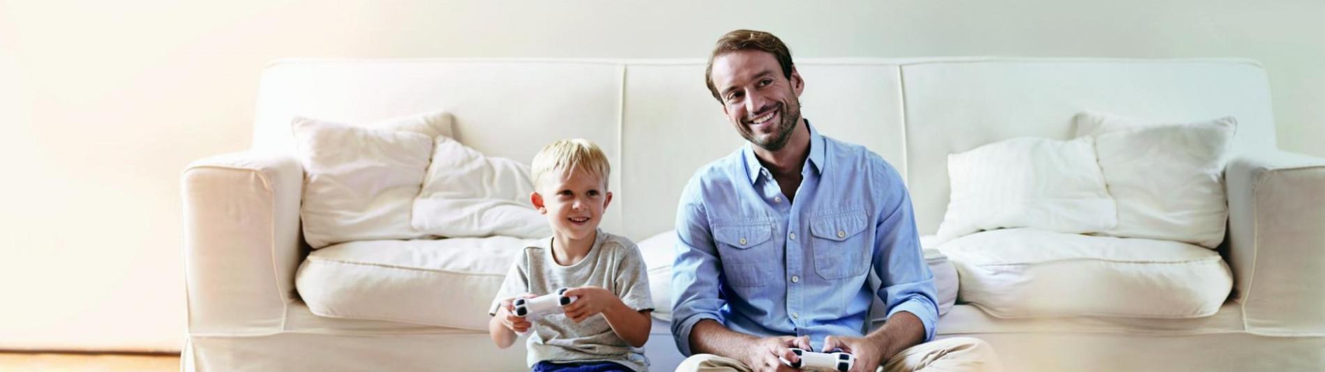 Vater und Sohn Videospiele vor weißer Couch mit sauberem und unabhängigen Strom aus der sonnenCommunity