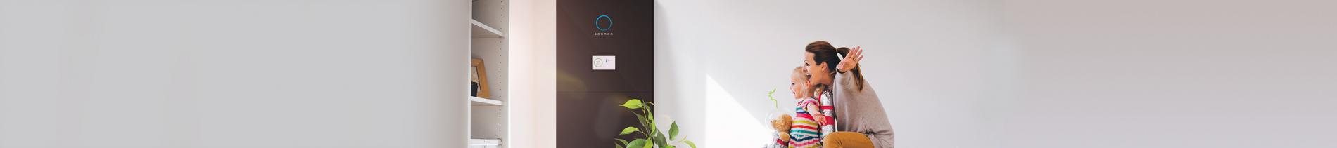 Mutter und Tochter auf dem Sofa mit einer schwarzen Solarbatterie