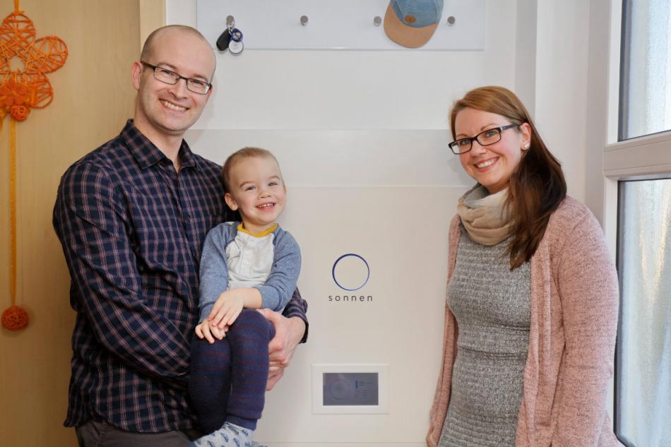 Familie: Mutter, Vater und Sohn vor dem Stromspeiche der sonnenBatterie