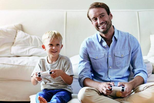Vater und Sohn lachend vor dem Sofa